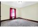 Bedroom with neutral walls and carpet, featuring window with red drapes and wood trim at 403 Colescott St, Shelbyville, IN 46176