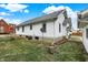 Rear exterior view of a charming white home with landscaped yard and a satellite dish at 403 Colescott St, Shelbyville, IN 46176
