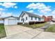 Charming white home featuring a detached garage and a paved driveway with a landscaped yard at 403 Colescott St, Shelbyville, IN 46176