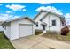 Exterior view of a white home with a detached garage and well-maintained landscaping at 403 Colescott St, Shelbyville, IN 46176