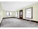 Bright living room featuring plush carpeting, neutral walls, and classic wood trim at 403 Colescott St, Shelbyville, IN 46176