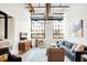 Living room with hardwood floors, large windows, and mid-century modern furniture at 630 N College Ave # 401, Indianapolis, IN 46204