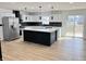 Modern kitchen features white cabinets, black backsplash, large island, and stainless steel appliances at 6775 N County Road 550 E, Brownsburg, IN 46112