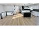 Bright, open-concept kitchen featuring stainless steel appliances, a large island, and modern black and white finishes at 6775 N County Road 550 E, Brownsburg, IN 46112
