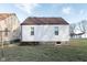 Backyard exterior featuring two windows, a brown roof, and green grass at 711 W 24Th St, Anderson, IN 46016