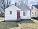 Charming single-story home featuring a red front door and a classic white exterior at 711 W 24Th St, Anderson, IN 46016