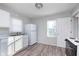 Functional kitchen featuring white cabinets, marble-look countertops, and modern appliances with wood-look floors at 711 W 24Th St, Anderson, IN 46016