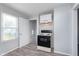 Bright eat-in kitchen with wood-look floors, range, window, and white door to exterior at 711 W 24Th St, Anderson, IN 46016