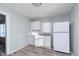 Eat-in kitchen with white cabinets, refrigerator, and sleek marble-look countertops and wood-look floors at 711 W 24Th St, Anderson, IN 46016