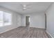 Bright living room with gray walls, wood-look floors, a ceiling fan, and a large window for natural light at 711 W 24Th St, Anderson, IN 46016
