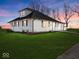 White farmhouse exterior with a gray roof, large yard, and landscaping at 7279 W State Road 44, Shelbyville, IN 46176
