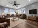 Spacious living room featuring leather furniture, a large TV, and hardwood floors at 7279 W State Road 44, Shelbyville, IN 46176