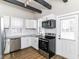 Modern kitchen with stainless steel appliances, white cabinets, and black accent beams at 747 E Mccarty St, Indianapolis, IN 46203