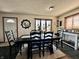 Dining area with a large table, six chairs, a sunlit window, and an exit door at 1072 S State Road 67, Martinsville, IN 46151