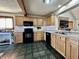 Functional kitchen featuring wood cabinets, black appliances, and laminate countertops at 1072 S State Road 67, Martinsville, IN 46151