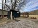 Backyard shed and chicken coop area with mature trees and gravel lot at 1072 S State Road 67, Martinsville, IN 46151