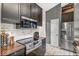 Modern kitchen features stainless steel appliances, dark cabinetry, and brick backsplash at 12525 Wolford Dr, Fishers, IN 46038