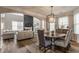 Open-concept dining area with hardwood floors and chandelier near the living room at 12755 Forsyth St, Carmel, IN 46032