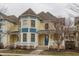 Inviting yellow townhouse with a covered porch, blue accents and manicured landscaping at 12755 Forsyth St, Carmel, IN 46032