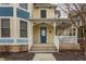 Covered front porch featuring blue door, 'welcome' sign, and adjacent bench seating at 12755 Forsyth St, Carmel, IN 46032