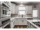 Well-equipped kitchen featuring stainless steel appliances, quartz countertops, and sleek white cabinets at 12755 Forsyth St, Carmel, IN 46032