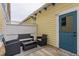 Outdoor patio featuring a seating area with wicker furniture, a blue door, and yellow siding at 12755 Forsyth St, Carmel, IN 46032