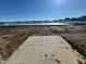 View of backyard, showing a concrete patio and a pond in the distance at 1407 Foxtail Ln, Greenwood, IN 46143