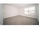 A bright bedroom with neutral carpet, white walls, and a window that offers natural light at 1407 Foxtail Ln, Greenwood, IN 46143