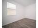Well-lit bedroom featuring gray laminate flooring, white walls, and a window with blinds at 1407 Foxtail Ln, Greenwood, IN 46143