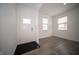 Bright entryway with white walls, gray laminate flooring, and a front door with decorative glass panels at 1407 Foxtail Ln, Greenwood, IN 46143