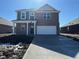 Charming two-story home with brick facade, covered porch, and attached two-car garage at 1407 Foxtail Ln, Greenwood, IN 46143