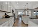 Modern kitchen with stainless steel appliances, white cabinets, and views of the living room at 15377 Manderley St, Fishers, IN 46040