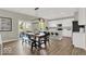 Open-concept dining area with a large table, bench seating, and views into the kitchen and outdoor patio at 16923 Sandhurst Pl, Westfield, IN 46074
