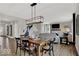 Modern dining area with a wooden table, black chairs, and an open view into the living room and kitchen at 16923 Sandhurst Pl, Westfield, IN 46074