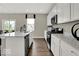 Bright and airy kitchen featuring white cabinets, stainless steel appliances, a kitchen island with bar stool seating, and hardwood floors at 16923 Sandhurst Pl, Westfield, IN 46074