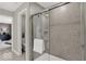 Close-up of a shower featuring gray-tiled walls, a glass door, and views into the toilet and bedroom at 16923 Sandhurst Pl, Westfield, IN 46074