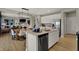 Bright kitchen with stainless steel appliances, white cabinets, island, and view to the living area at 16960 Sandhurst Pl, Westfield, IN 46074