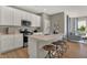 A kitchen island with white cabinets, quartz countertops, stainless steel appliances, and bar stool seating at 16960 Sandhurst Pl, Westfield, IN 46074
