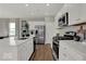Bright kitchen featuring stainless steel appliances, white cabinetry, and a large center island at 16966 Sandhurst Pl, Westfield, IN 46074
