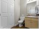 Neat bathroom with storage cabinet, toilet, and mirror at 2231 Colfax Ln, Indianapolis, IN 46260