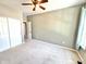 A clean, carpeted bedroom with light-colored walls has a ceiling fan and closet at 2231 Colfax Ln, Indianapolis, IN 46260