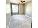A clean, carpeted bedroom with a ceiling fan and a large window lets in plenty of natural light at 2231 Colfax Ln, Indianapolis, IN 46260
