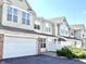 Inviting townhouse showcasing attached garage, neutral siding, and well-maintained landscaping at 2231 Colfax Ln, Indianapolis, IN 46260