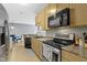 Functional kitchen boasts stainless steel appliances, updated countertops, and wood flooring at 2231 Colfax Ln, Indianapolis, IN 46260