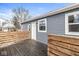 View of the backyard deck with wooden railing, gray siding, and a door leading into the house at 2421 E 11Th St, Indianapolis, IN 46201