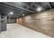 Finished basement with a light gray floor, exposed ceiling, and beautiful horizontal wooden wall at 2421 E 11Th St, Indianapolis, IN 46201