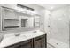 Bathroom with a double sink vanity, large mirror, and a glass-enclosed shower featuring marble-look tiling at 2421 E 11Th St, Indianapolis, IN 46201