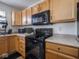 Well-equipped kitchen featuring black appliances and light wood cabinets at 3143 Shadow Lake Dr, Indianapolis, IN 46217