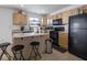 Modern kitchen with light wood cabinets and black appliances at 3143 Shadow Lake Dr, Indianapolis, IN 46217