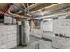 Unfinished basement with exposed pipes, brick walls, and a water heater at 350 E Minnesota St, Indianapolis, IN 46225